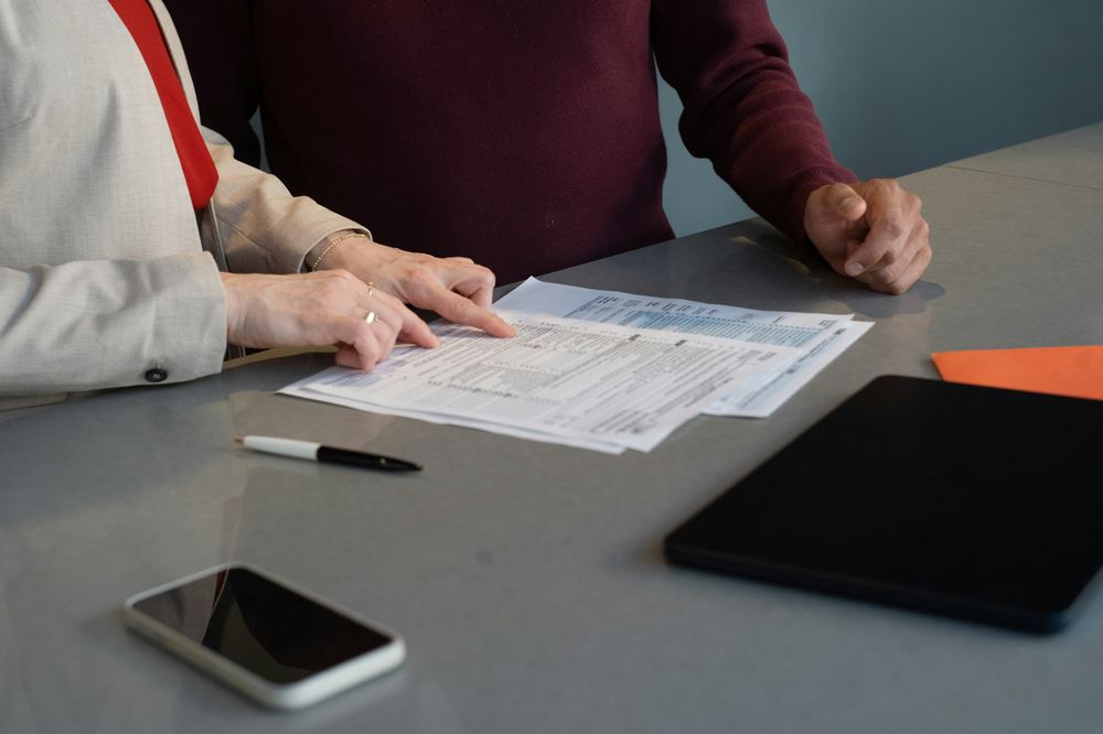 Close-up of two people reviewing a proposal document together